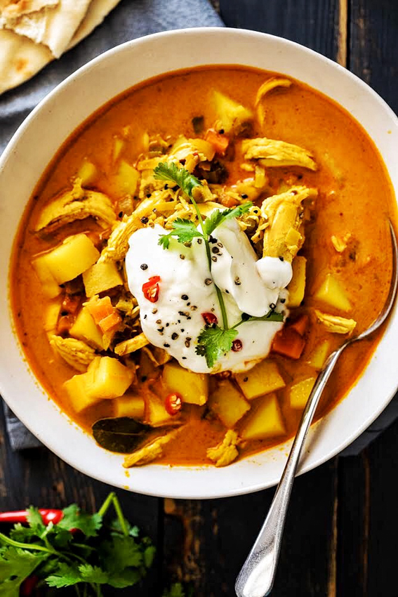 Chicken curry soup in bowl with spoon.