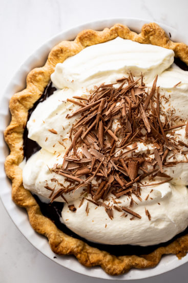 Chocolate cream pie with whipped cream and chocolate shavings.