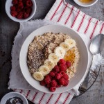 Creamy oatmeal bowls with raspberries, seeds and honey