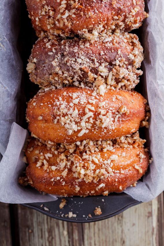 Soft, fluffy yeasted doughnuts covered in caramel glaze and dunked in crunchy cinnamon-flavored nuts.