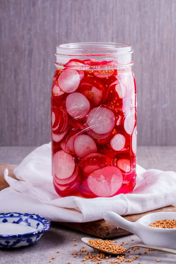 Easy pickled radishes in jar with pickling spices. 