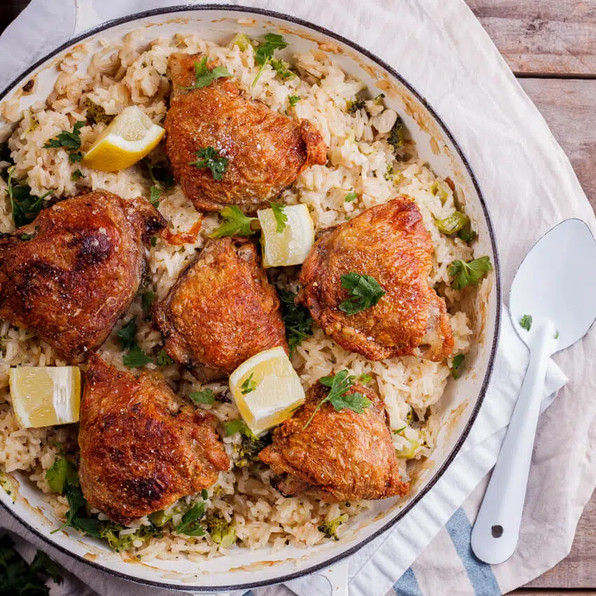 Crispy chicken thighs on cheesy broccoli rice