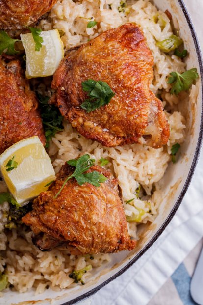 Crispy chicken thighs on cheesy broccoli rice - Simply Delicious