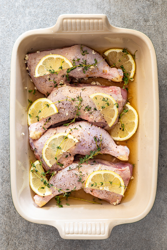 Chicken pieces in pan with fresh lemon.