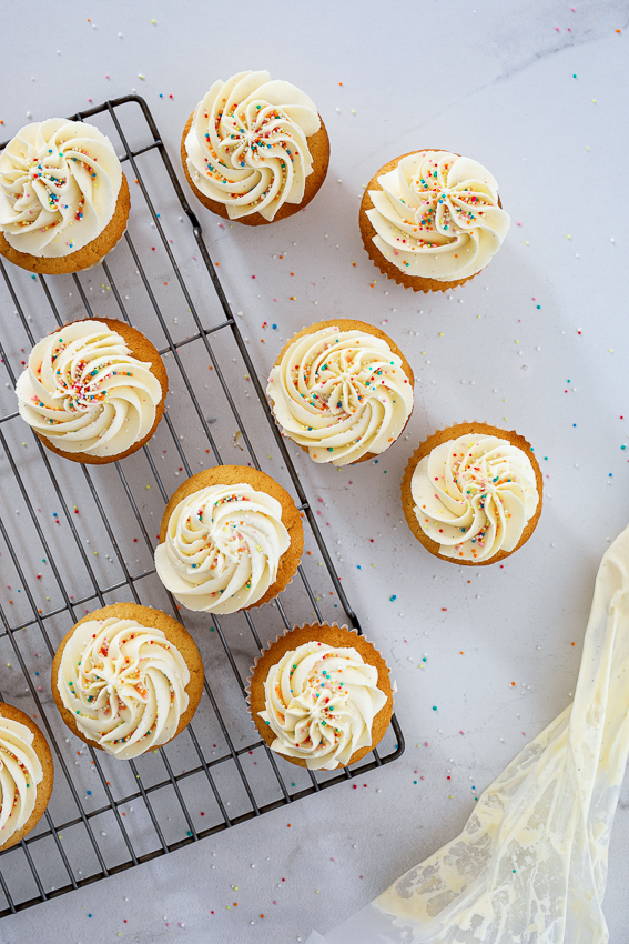 Vanilla cupcakes topped with swirls of whipped buttercream.