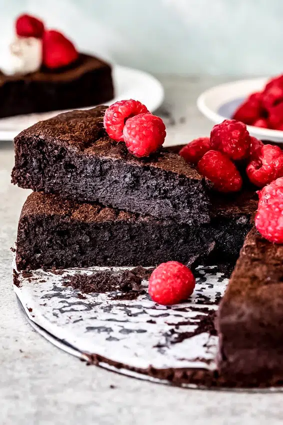Flourless chocolate cake topped with fresh raspberries.