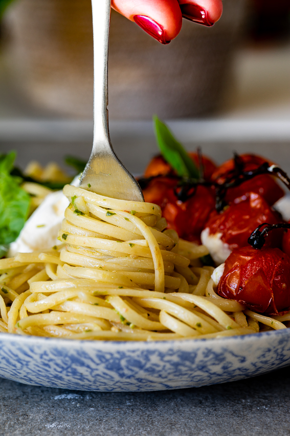Pesto pasta twirled around a fork.