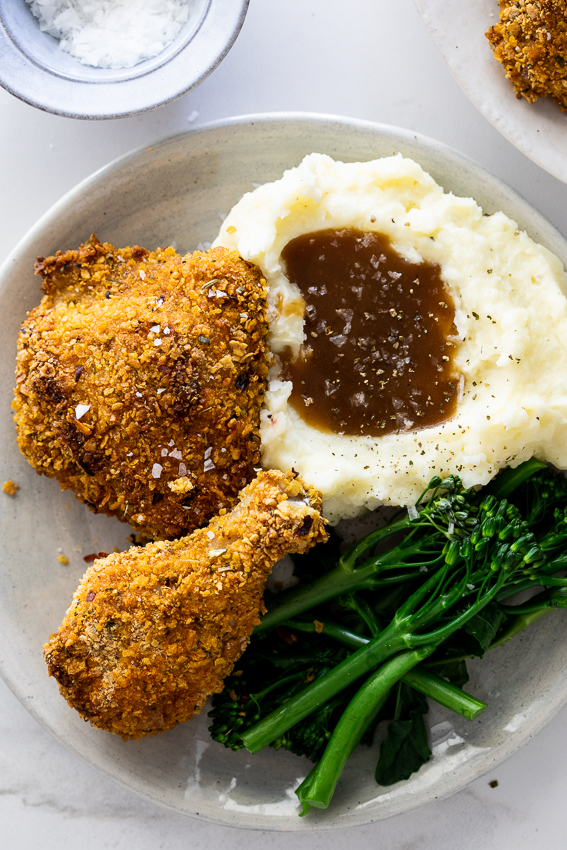 Baked cornflake chicken with mashed potatoes and gravy.