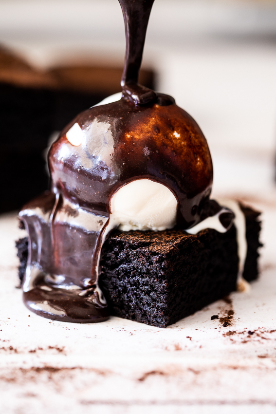 Chocolate brownies served with ice cream and chocolate sauce.