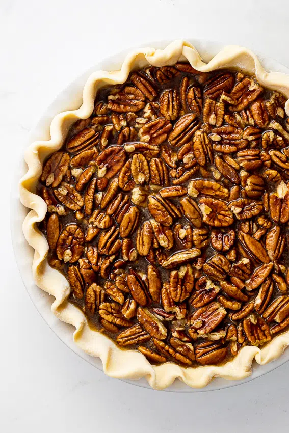 Gooey pecan pie filling in homemade pie crust.