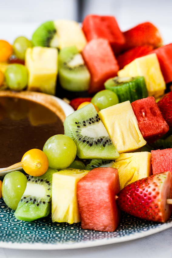 Fresh fruit skewers with chocolate sauce.