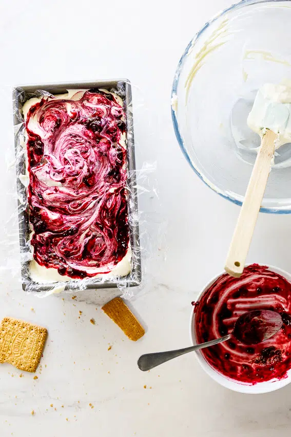 Icebox cake being layered with blueberry sauce.