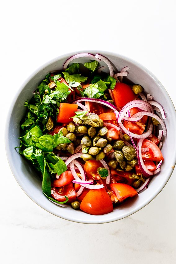 Easy tomato salad with capers, herbs and red onion.