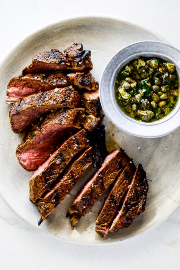 Medium rare sirloin steak with caper sauce.
