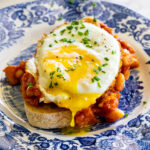 High Protein Cowboy Beans topped with a fried egg on crusty toast.