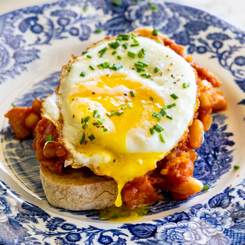 High Protein Cowboy Beans topped with a fried egg on crusty toast.