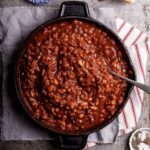 Sweet and smoky cowboy beans in a black skillet.