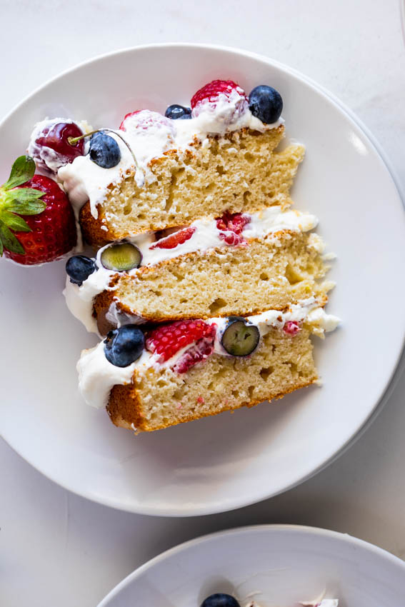 Slice of cake with berries and cream.