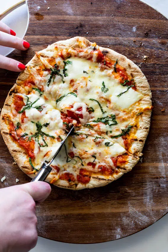 Fresh pizza getting cut.