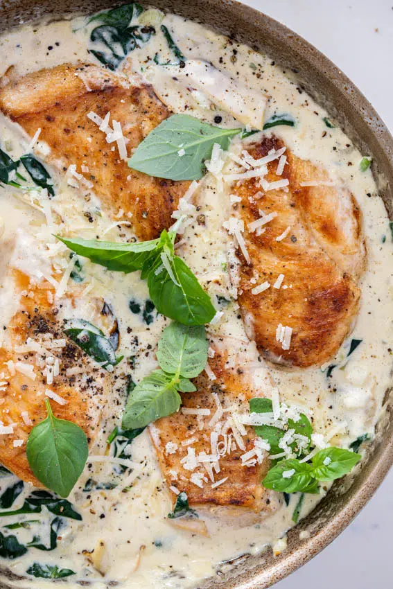 Juicy pan-seared chicken breasts in creamy spinach artichoke sauce.