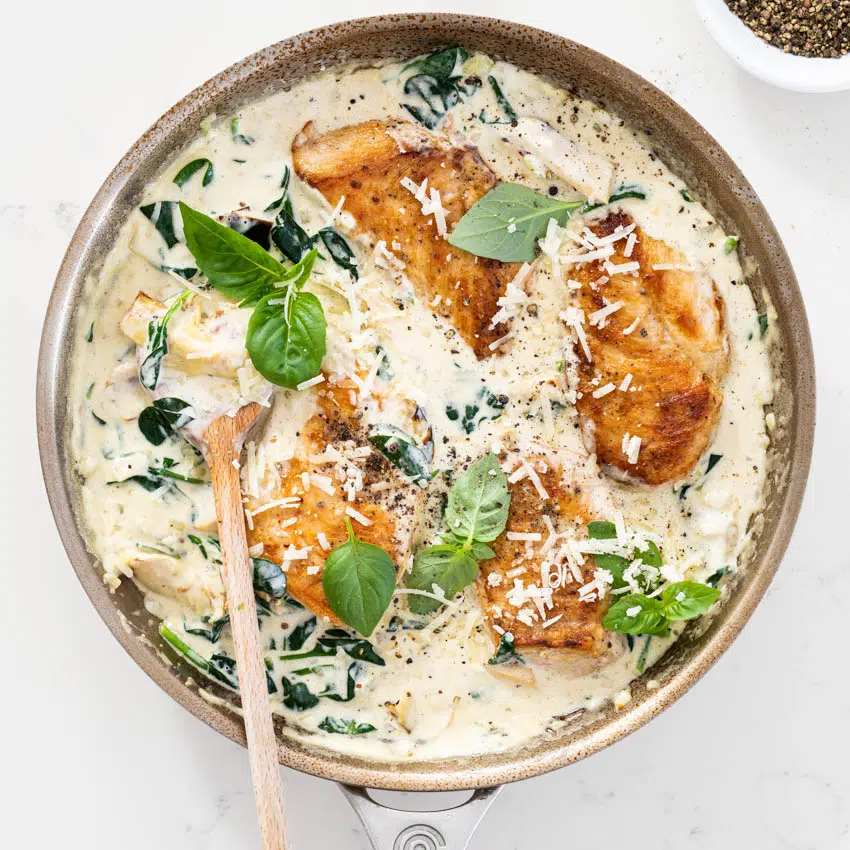 Juicy pan-seared chicken breasts in creamy spinach artichoke sauce.