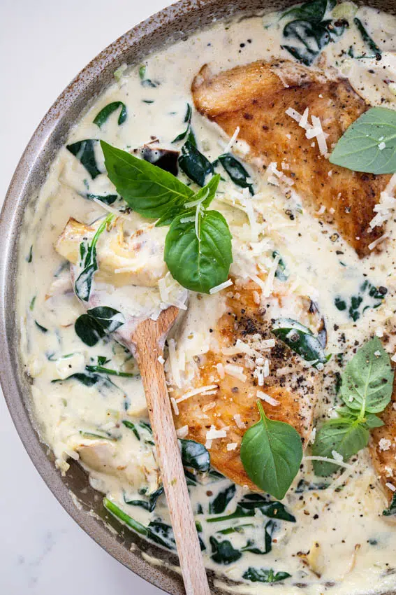 Creamy spinach artichoke chicken with fresh basil.