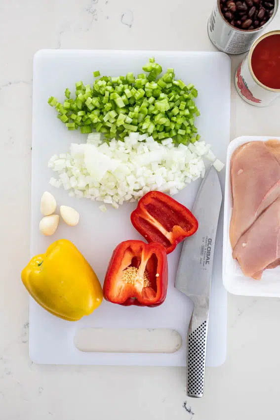 Ingredients for chicken black bean soup. Chicken breasts, peppers, onions, celery, tomato and black beans.