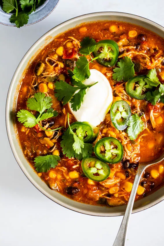 Chicken black bean soup cooked in an Instant Pot served with sour cream and jalapenos.
