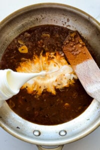 Cream poured into sauce.