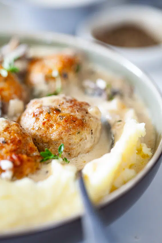 Juicy chicken meatballs in creamy mushroom sauce with mashed potatoes.