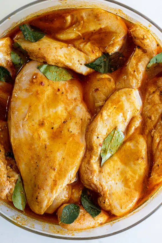 Chicken breasts in curry marinade.