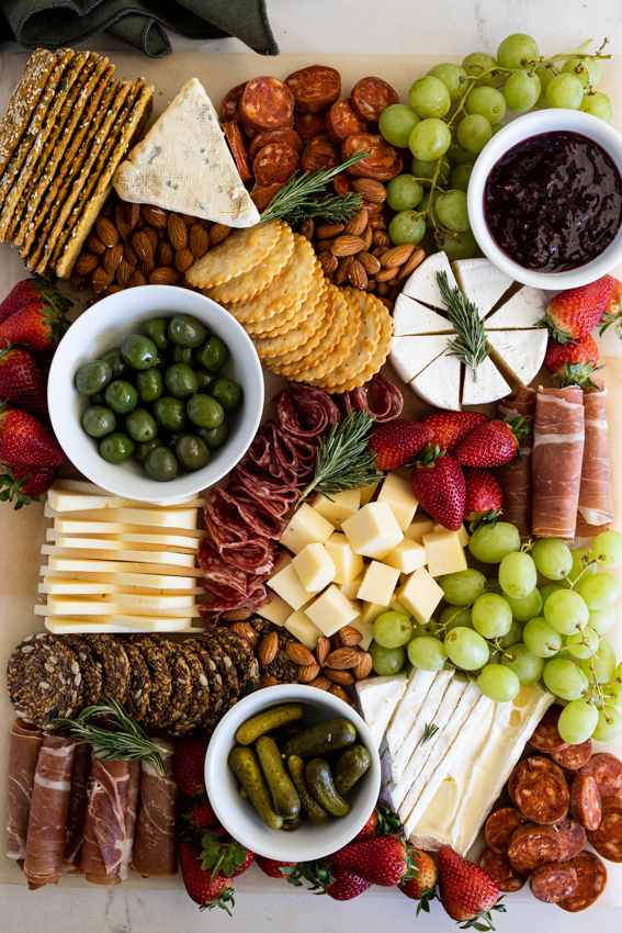 The ultimate cheese board with meats, fresh fruit, olives and crackers.