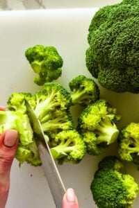 Slicing broccoli florets off the head of broccoli.