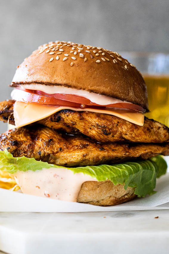 Juicy grilled chicken burgers with lettuce, tomatoes and cheese