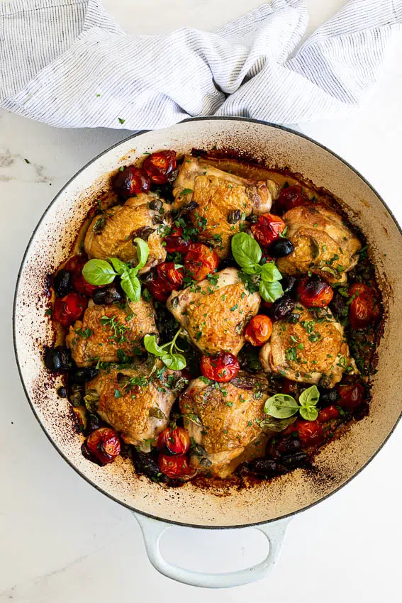 Mediterranean chicken in pan with tomatoes, capers and olives.