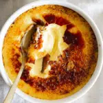 Crème brûlée with perfectly smooth custard with a spoon cracked through.