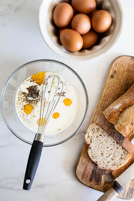 Eggs and cream in bowl with sourdough bread.