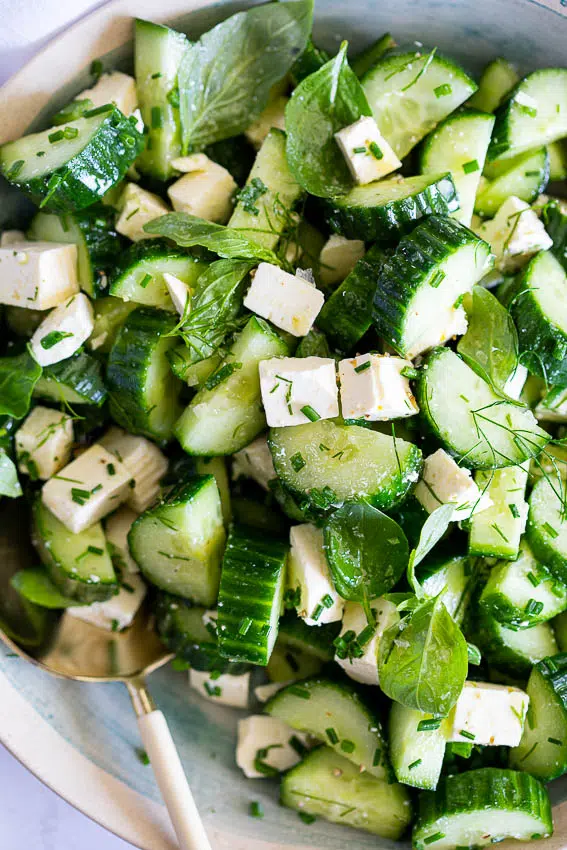 Easy cucumber feta salad with fresh herbs in a bowl.