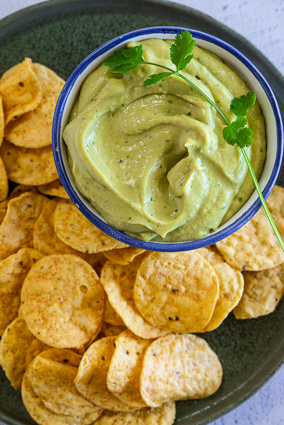 Creamy avocado sauce served with chips.