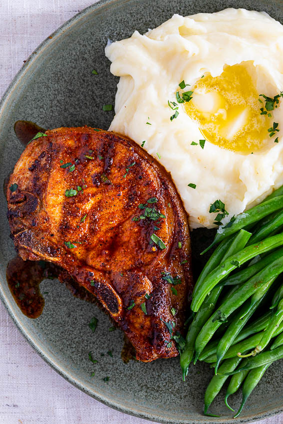 Pork Chops served with mashed potatoes and green beans.