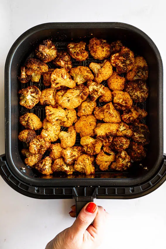 Cauliflower in air fryer basket.