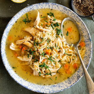 Lemon chicken orzo soup in serving bowl with spoon