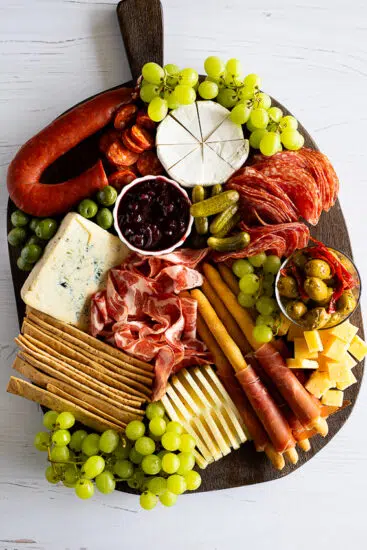 Easy Charcuterie Board with a selection of cheeses, meats, grapes and crackers.