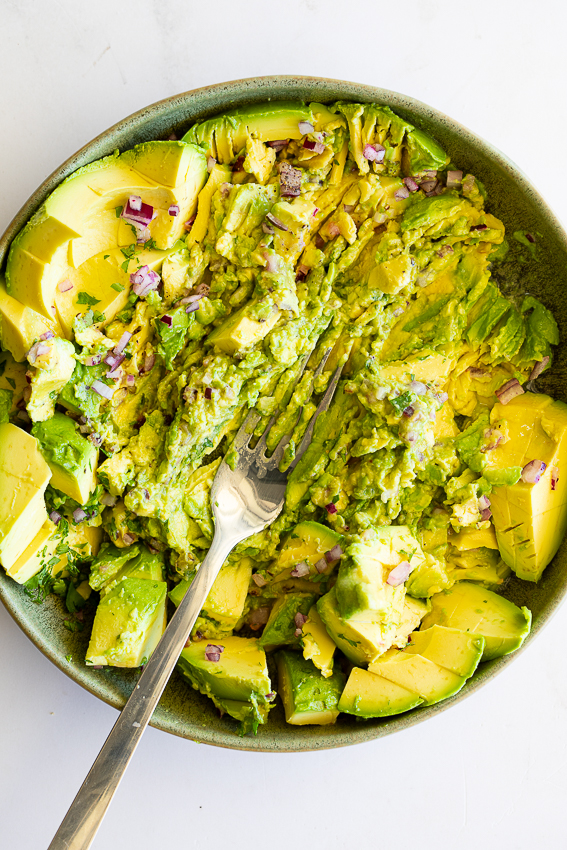 Mashed guacamole in bowl.