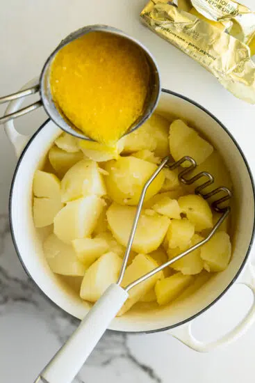 Garlic Parmesan Mashed Potatoes being mashed