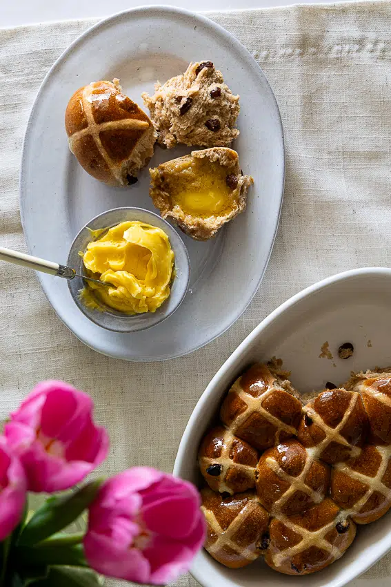 Air fryer hot cross buns served with honey butter.