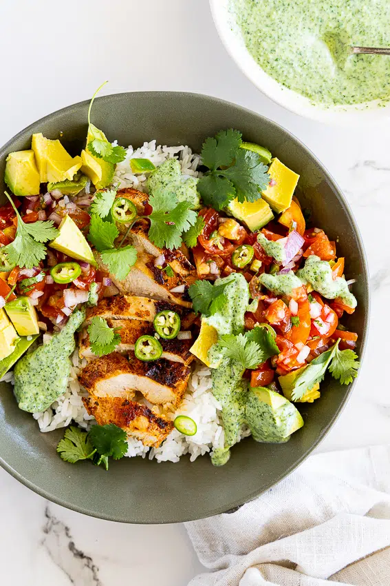Chicken taco bowls with pico de Gallo, avocado, cilantro sauce and rice.
