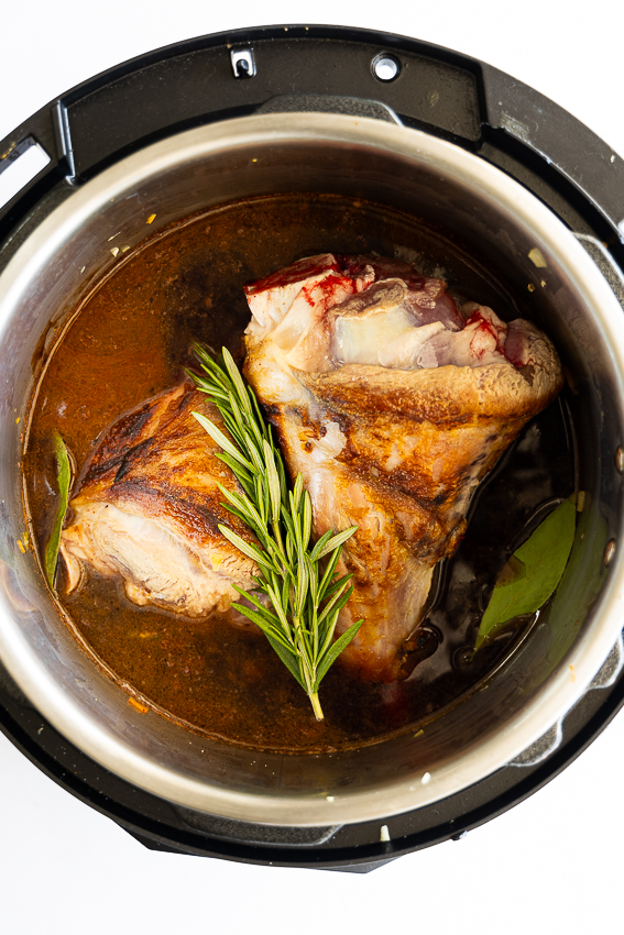 Lamb shanks in Instant Pot with aromatics.