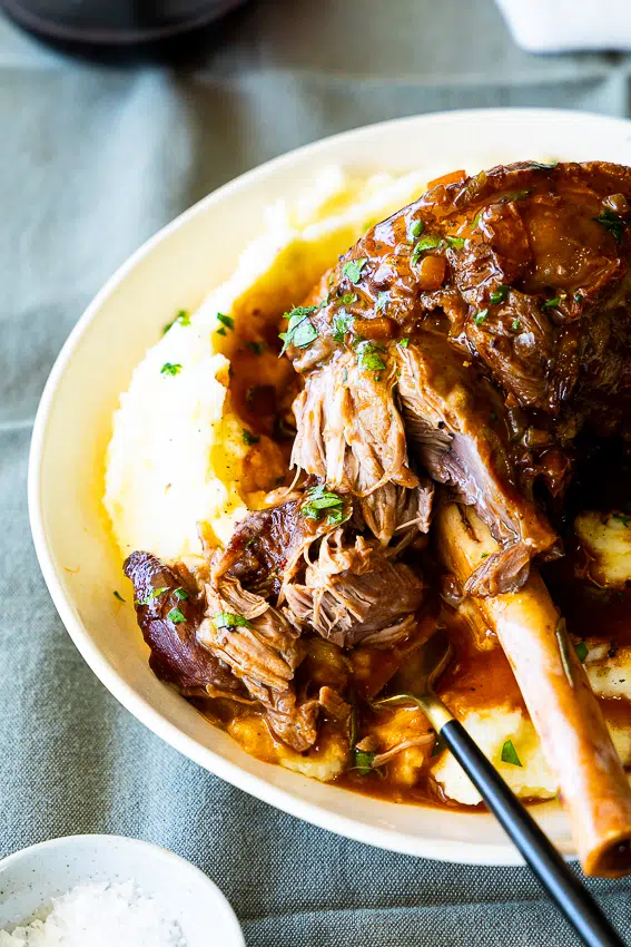 Instant Pot Lamb Shanks on creamy mashed potatoes.