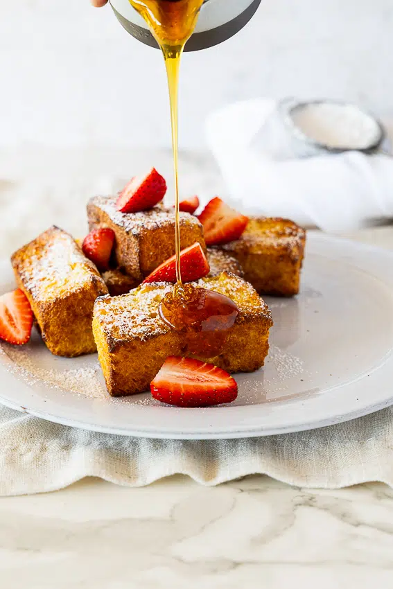 Air Fryer French Toast fingers with maple syrup and strawberries.